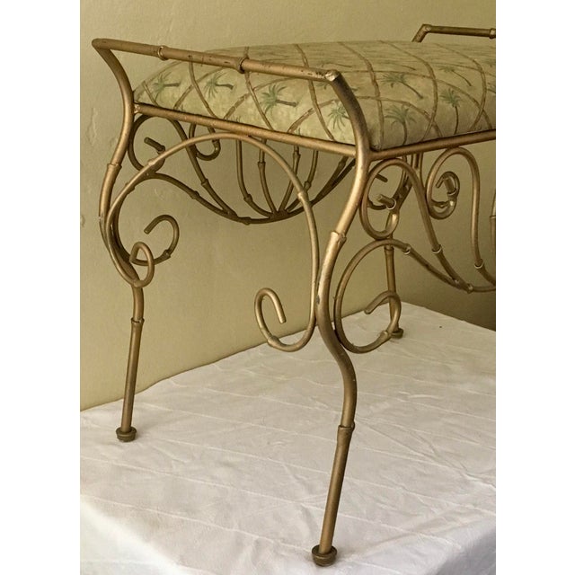 Vintage Hollywood regency style cushioned vanity bench. Measures roughly 21” length x 14” depth x 18” height. Date...
