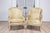 A pair of French Louis XVI style painted bergères à oreilles from circa 1900 with carved acanthus leaves and fluted legs....