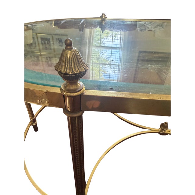 Neoclassical Jansen style brass and glass elliptical coffee table having large pinecone finials, manner of Maison Baguès,...