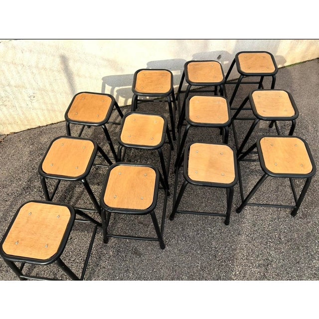 Set of 12 industrial stools, sandblasted and painted black. The seat cushions have been restored and waxed. Seat height: 45cm