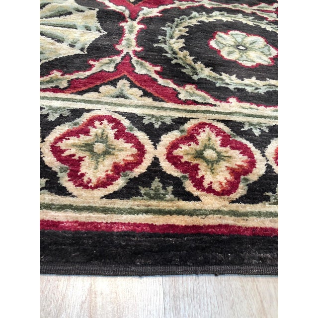 A handwoven wool flatweave, made in India and measuring 12'6"' x 16'. Floral drawing carried across the field inside a...