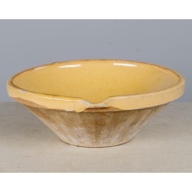 An early 20th century Country French yellow glazed earthenware pottery tian or grésale bowl. Originating from Provence and...