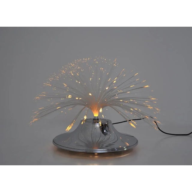 Table lamp with aluminum base and optical fiberglass feather feathered with scrolling colors. The lamp turns on itself or...