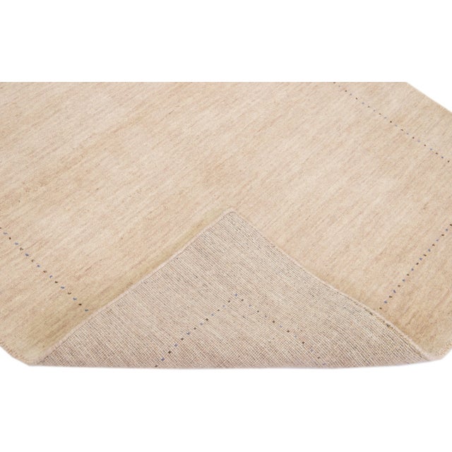Beautiful modern Gabbeh Style hand-Loom wool rug with a beige field with gorgeous solid design. This rug measures: 4'2" x...