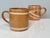 These two handcrafted ceramic mugs bear the distinctive signature of ceramic artist Helma Klett (1908-1996). with their...