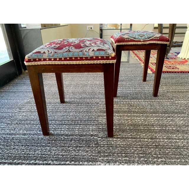 Beautifully aged wood stools with a beaded upholstery seat. Striking color way including burgundy, turquoise and pink....