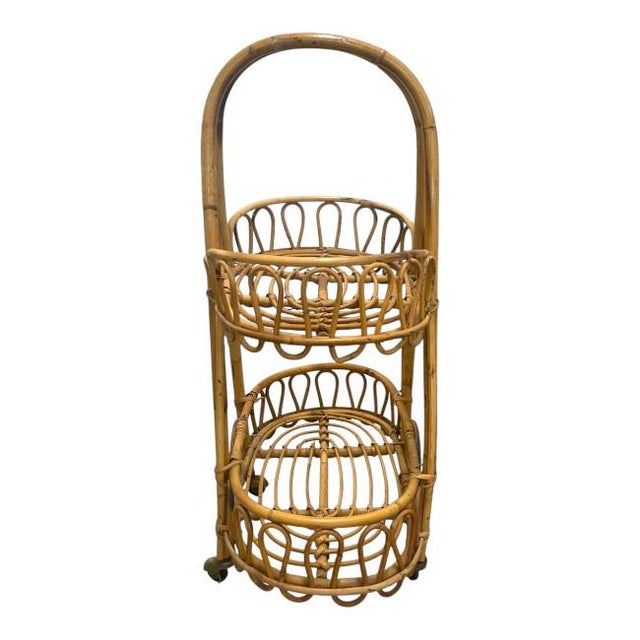 Vintage Rolling Rattan Plant Stand / Utility Cart A beautifully crafted vintage rattan rolling cart featuring two...