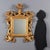 Small carved and gilded mirror. Moulded and engraved frame, embellished with Baroque carvings of leaves, scrolls, and...