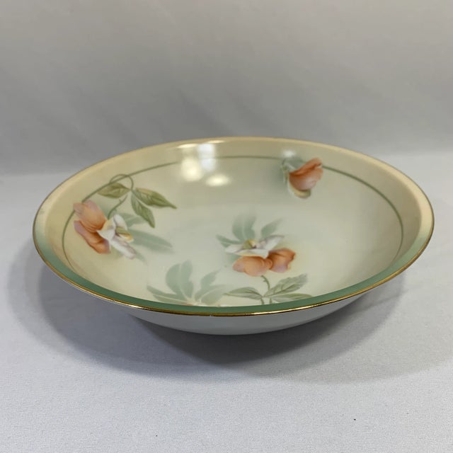This is a hand-designed mid-century pleasing soft pastel blue-green and peach floral bowl with gold trim around stamped RS...