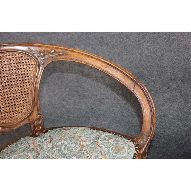 This elegant pair of French Art Nouveau walnut armchairs beautifully captures the organic grace and artistic innovation...