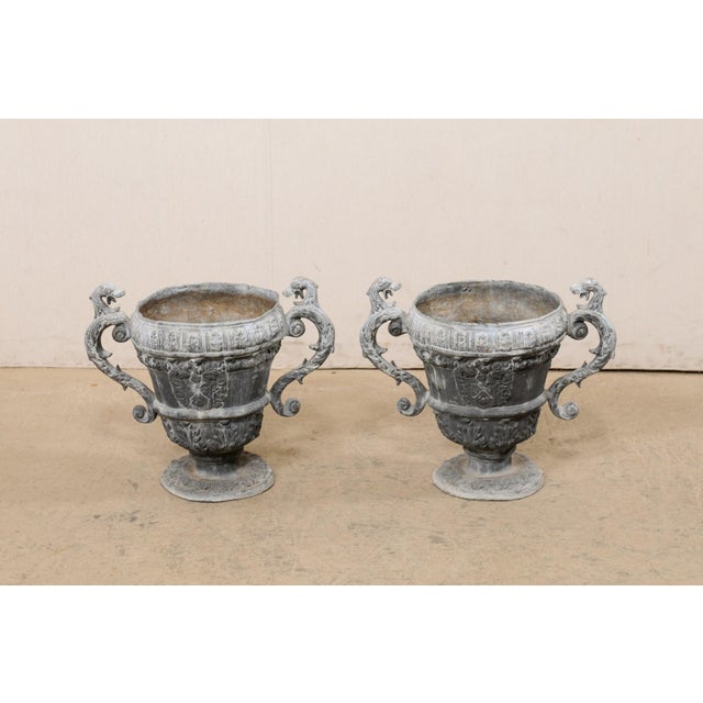 A French pair of decorative urn planters from the 18th century. This antique pair of lead garden ornaments from France...