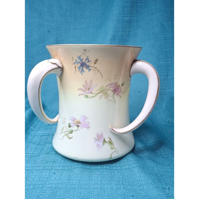 This exquisite late 19th-century vessel by Doulton Burslem (Nile Street, England) features the rare triple-handle...