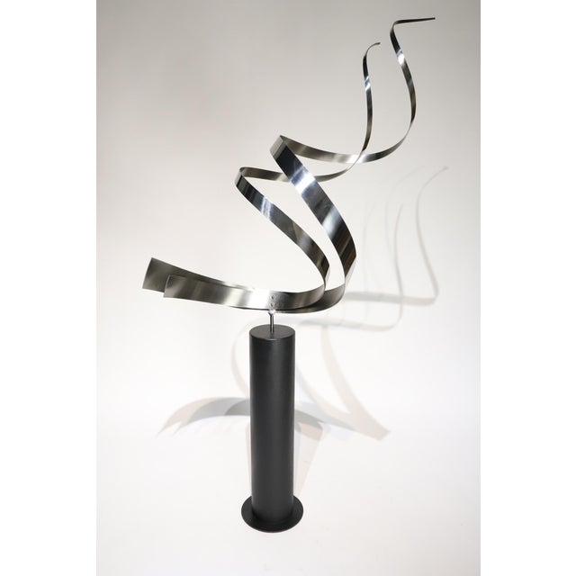 Stunning stainless steel “swirl” floor sculpture by Curtis Jere. Swirl sits atop a painted black steel base and swivels,...
