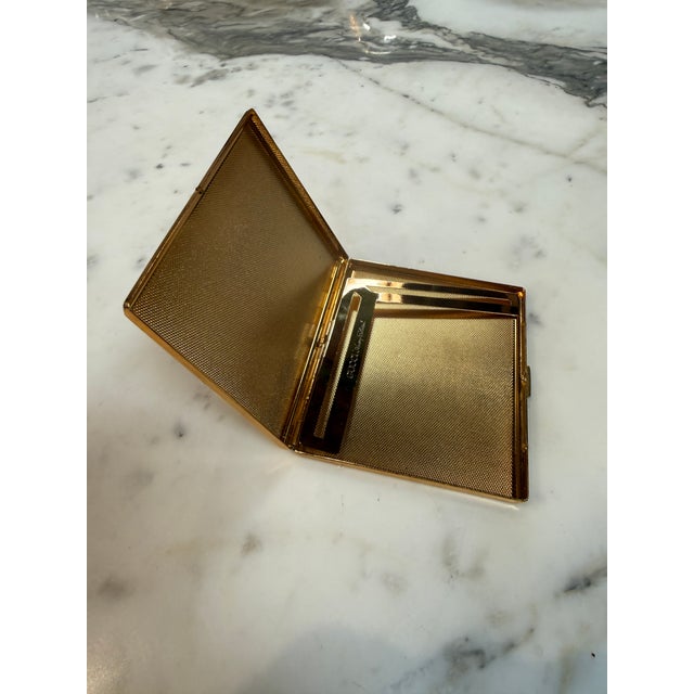 A refined Gucci cigarette case crafted in Italy during the 1970s, featuring a polished gold-plated frame paired with a...