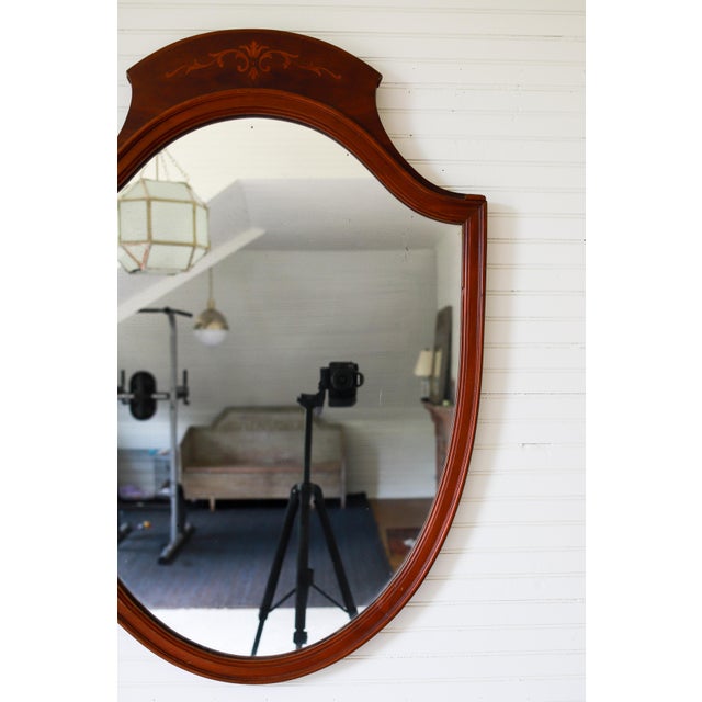 This charming Federal style shield mirror dates to the 1920s - 1940s. The handsome mahogany frame features a gracefully...