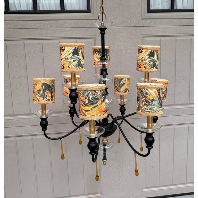 The hand made shades on this black and gold metal chandelier are done in a fabric with a marbleized pattern. I was always...