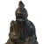 A Chinese bronze seated deity. In one hand he holds a small piece of fruit. In the other a short staff with an animal hair...