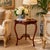 Elegant vintage end table crafted of mahogany wood, featuring a distinctive shaped top with a raised scalloped gallery...