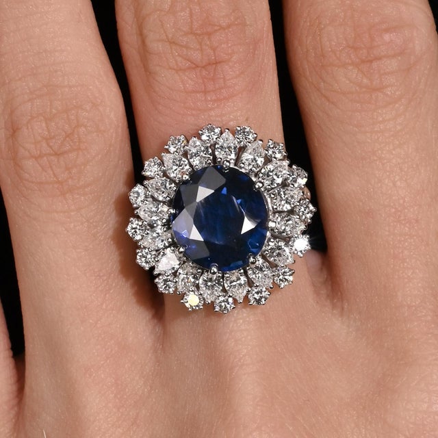 GRS Certified 7.15 Carat Vivid Blue Sapphire and Diamond Halo Vintage Ring, Made In France. Set in lustrous 18K white...