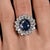 GRS Certified 7.15 Carat Vivid Blue Sapphire and Diamond Halo Vintage Ring, Made In France. Set in lustrous 18K white...