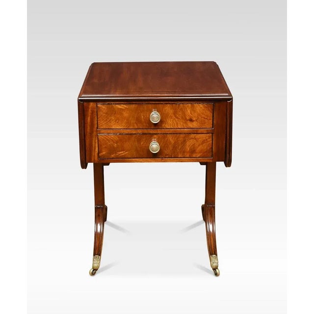 Regency mahogany lamp table of small proportions, the rounded rectangular string inlaid top above two frieze drawers with...