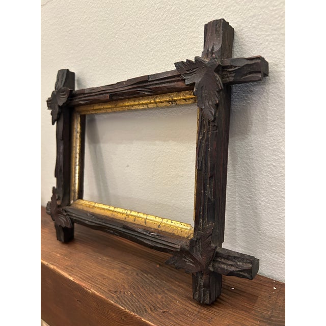 Hand carved wooden frame featuring bold Black Forest style detailing with deeply textured surfaces and applied foliate...