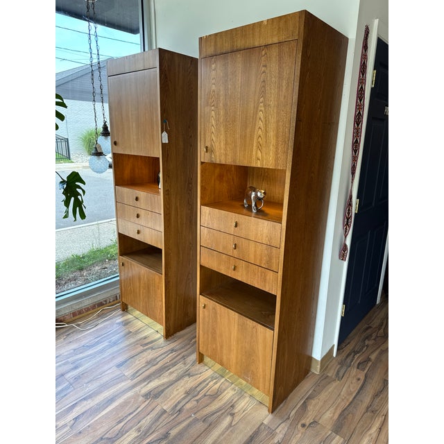 Matching set of mid century Founders wall units. Each piece features upper and lower cabinet compartments, 3 central...