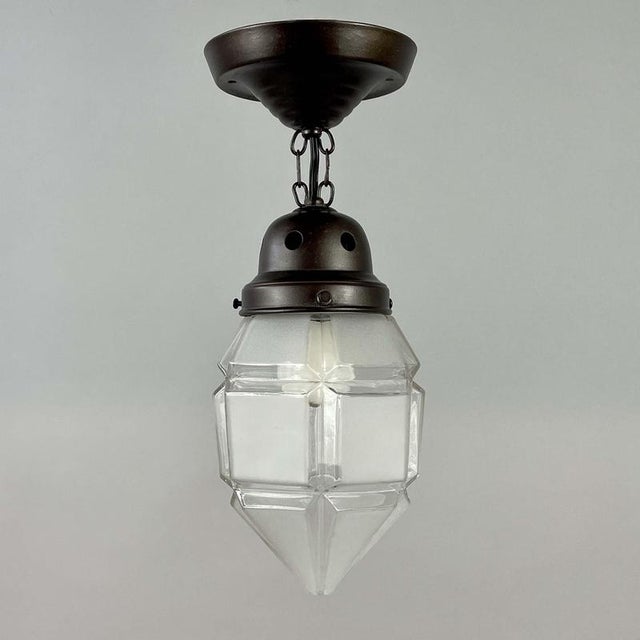 This pretty semi flush mount was designed and manufactured in Austria in the 1920s. It features a frosted geometric glass...
