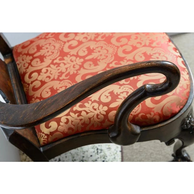 Pair of painted carved and inlaid arm chairs. Lovely inlaid floral scene on the back splat. Highly carved panel on the top...