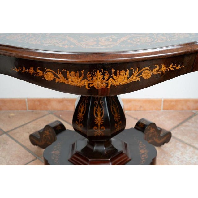 Antique center table crafted from fine exotic woods, originating from Nice, France. The oval, biscuit-shaped top features...