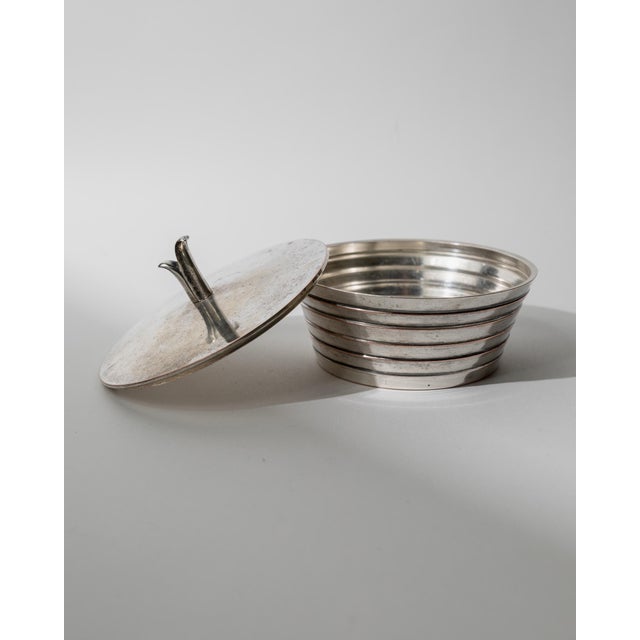 This vintage silver-plated lidded bowl from the 1950s features an elegant tiered form enriched by a sculptural abstract...