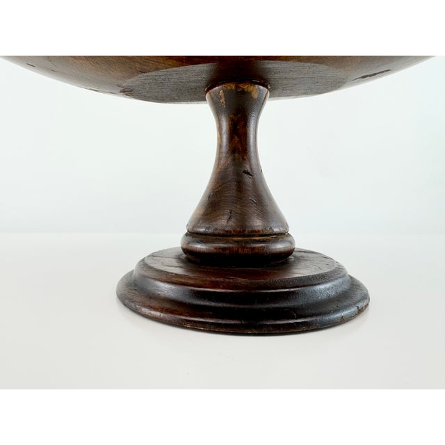 A substantial vintage wood centerpiece bowl with a beautifully elongated oval form raised on a turned pedestal base....