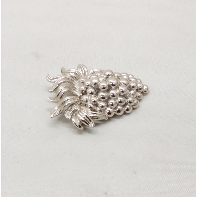 This is part of Chairish’s Costume Jewelry assortment. Circa 1970s rhodium plated 3d grapes brooch with security clasp....
