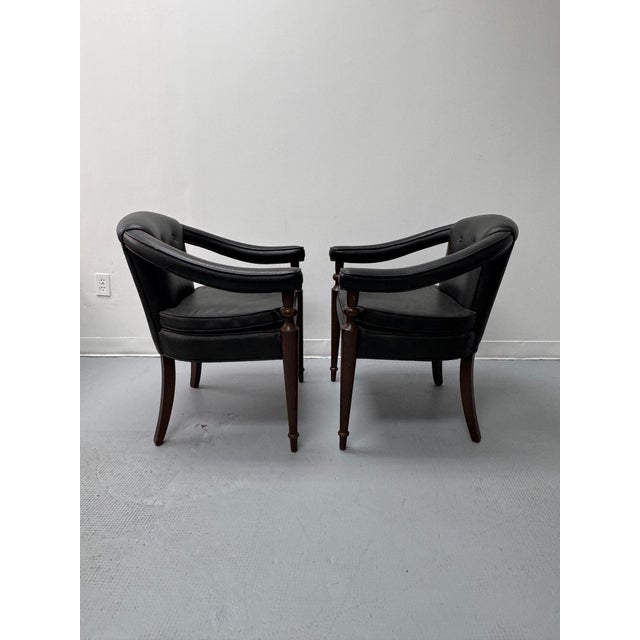 A sophisticated pair of vintage barrel-back tub armchairs dating to the 1970s, featuring gracefully curved backs, button-...