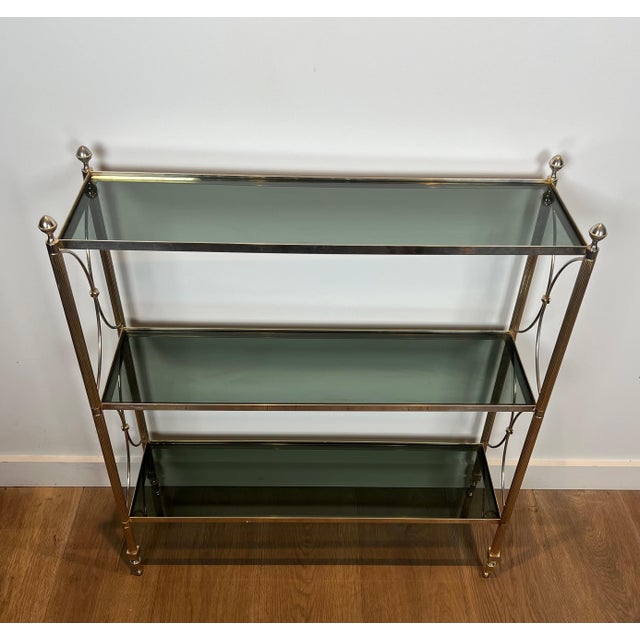 View in original language This neoclassical-style shelf is made of silver-plated metal and tinted glass. It is a French...