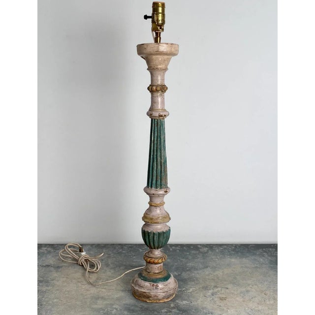 A early 19th-century Italian painted pricket mounted as a lamp in dark green and cream with gilt accents.
