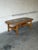 This oval coffee table features an inset ceramic tile top with an artistic radial motif. Sculpted legs and a stretched...