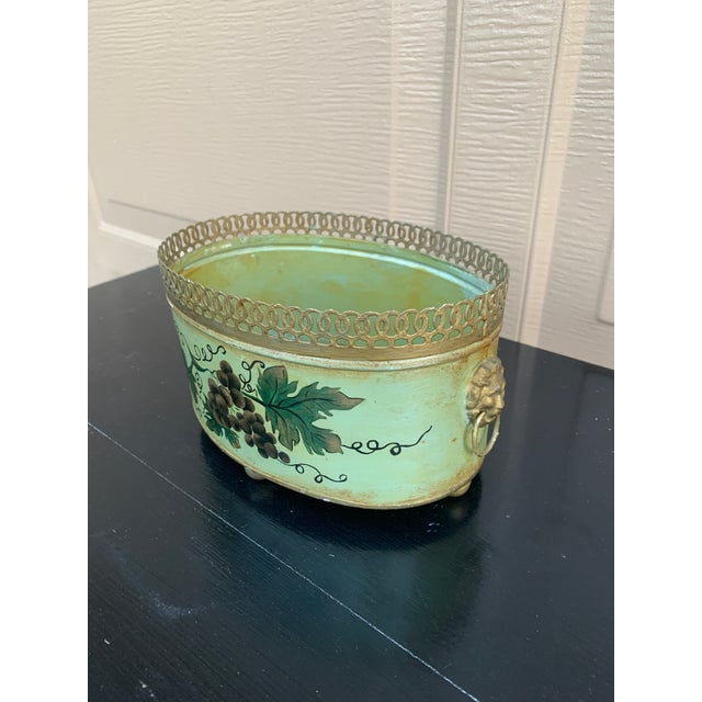 A gorgeous neoclassical green & gold tole cachepot, planter, or vase with hand painted grape vines and gilt lion head...