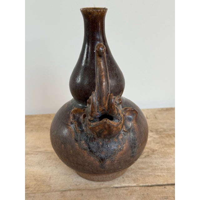 This is a vintage ceramic figural elephant vase.