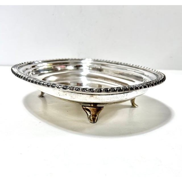 Vintage silverplate footed serving tray by L.B.S. Co. featuring a classic rope-edge border and low-profile pedestal feet,...