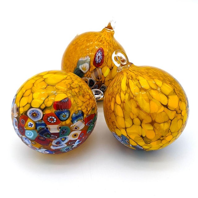 Set of three Christmas baubles in authentic Murano glass, decorated with lively murrine and an elegant light amber yellow...
