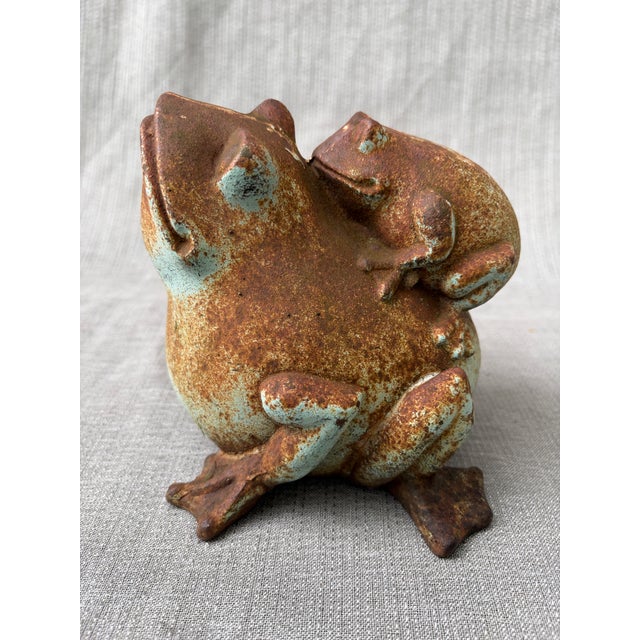 This is a whimsical, vintage cast iron version of a Japanese Shigaraki Ware frog and carrying a toadlet doorstop, garden...