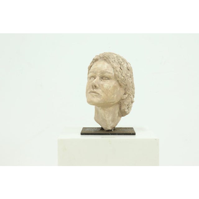 Studio made portrait head crafted in natural clay, dating from the 1970s. Part of a series of seven individually sculpted...
