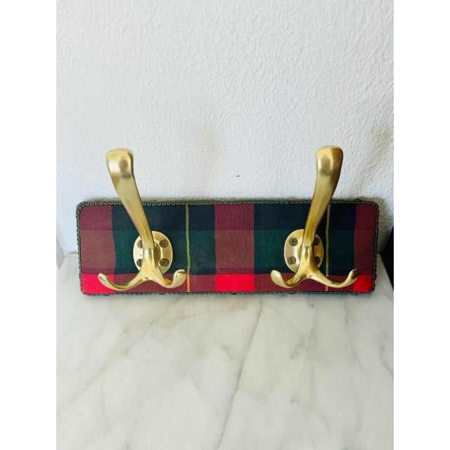 This charming vintage coat rack, handmade and purchased in Brussels, features a classic plaid backing and two elegant...