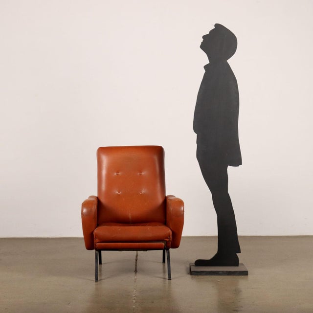 Armchair with removable footrest and reclining backrest, foam padding, skai covering, enamelled metal legs. An armchair to...