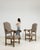 A striking pair of 19th century oak armchairs inspired by medieval “castle” seating, featuring high backs and strong...