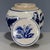 This round lidded jar features a classic crackle glaze cream ceramic body decorated with bold blue-and-white hand-painted...