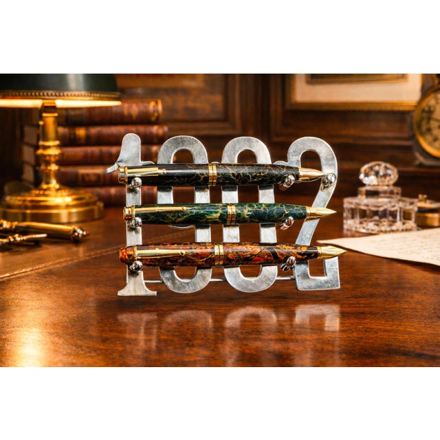 A rare and highly distinctive desk accessory, this 1902 cut-out year pen rest stand by Tiffany & Co. is a striking example...