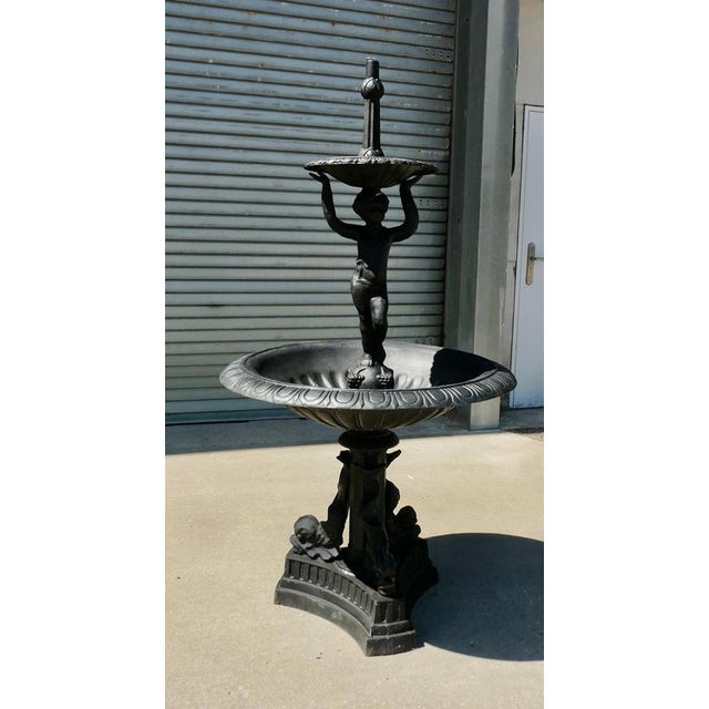 Black Cast Iron Fountain with Cherub Boy A good piece in a classical style with dolphins at the base and a cherub boy This...
