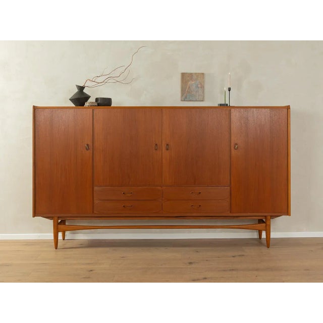 Wonderful highboard from the 1960s in Scandinavian design. High-quality body in teak veneer with four cabinet doors, six...